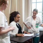 Nursing students talk with a patient